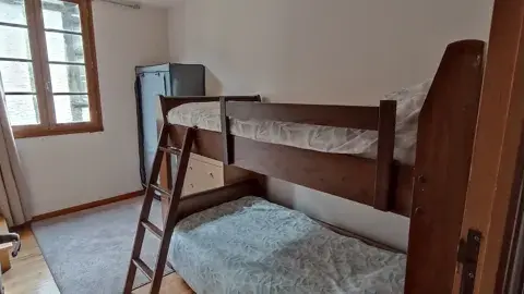 Chambre lumineuse équipée d’un lit superposé en bois, idéale pour accueillir plusieurs personnes