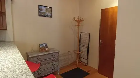 Entrée fonctionnelle avec meuble de rangement et porte-manteau, offrant un accueil pratique dès l’arrivée.