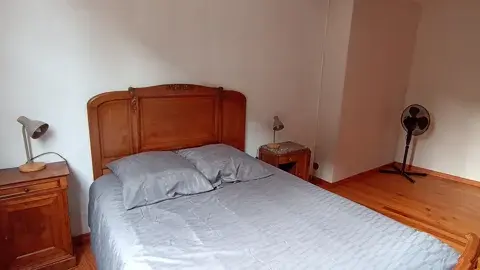 Chambre spacieuse avec lit double, tables de chevet et ventilateur pour plus de confort.