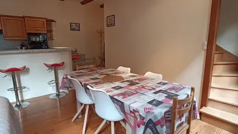 Salle à manger conviviale avec grande table familiale et accès direct à la cuisine ouverte
