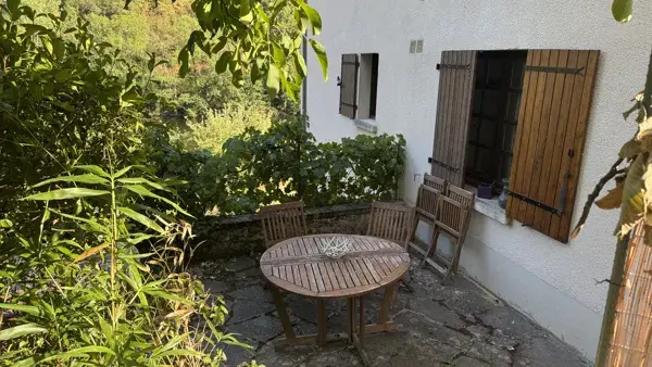 Terrasse privative et ombragée avec table et chaises en bois