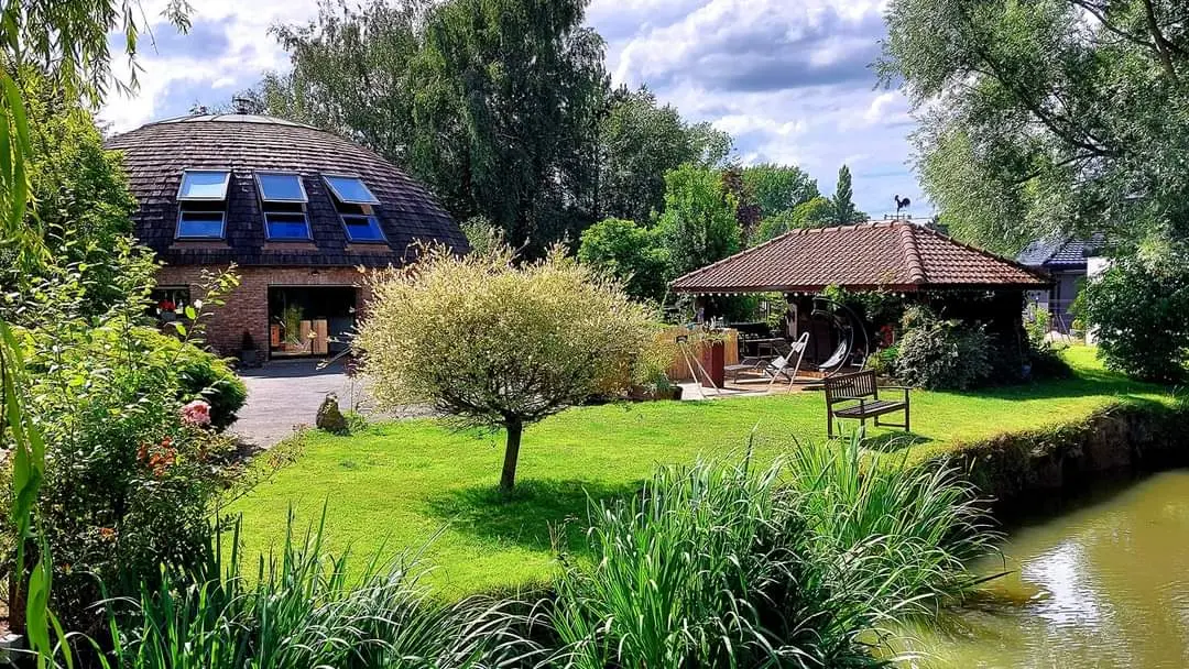 Maison dôme dans un parc arboré avec étang