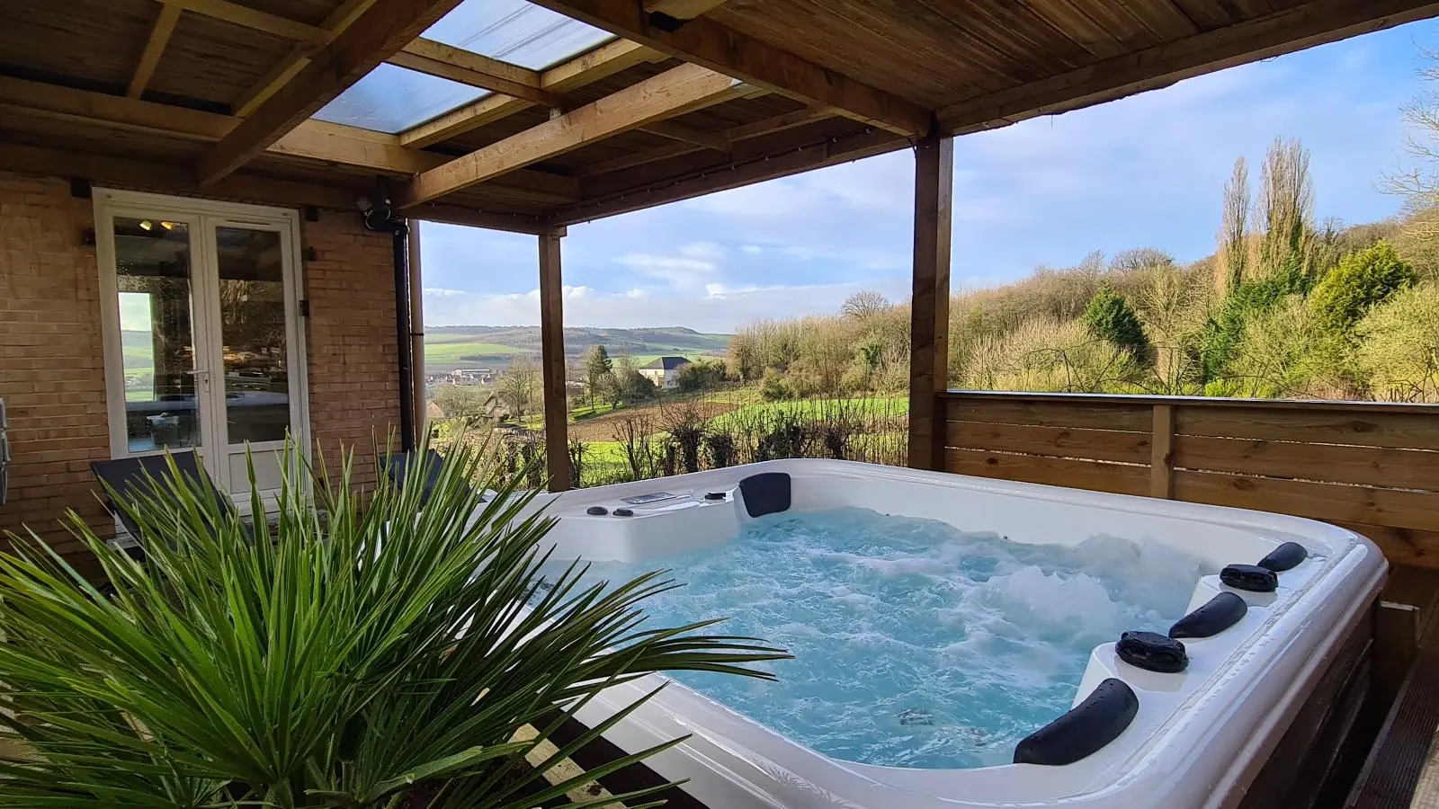 Jacuzzi sous pergola avec panorama sur la vallée de la Hem