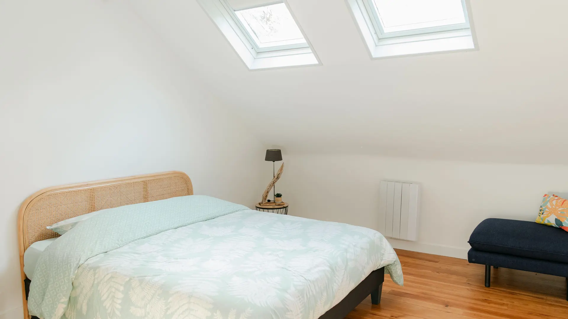 Grande chambre avec lit double, penderie et prises USB autour du lit