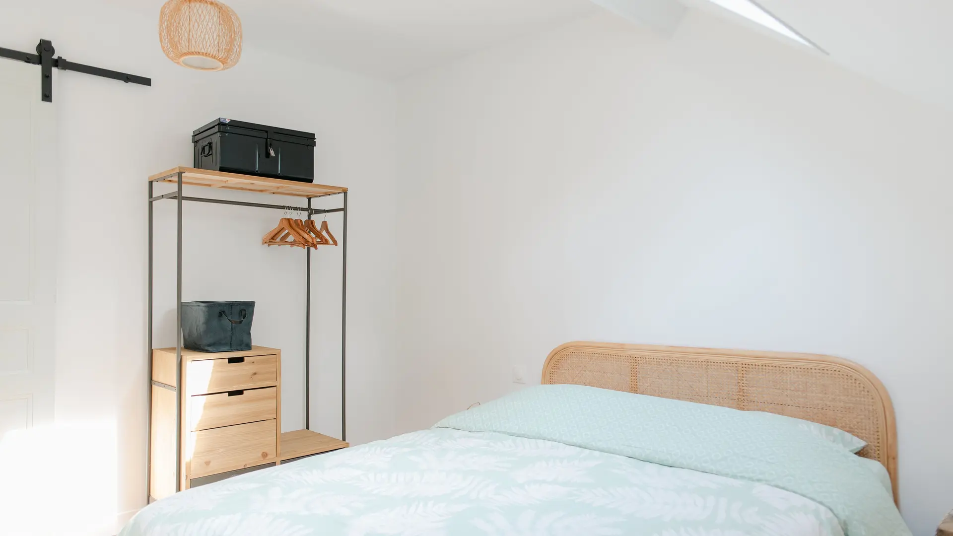Grande chambre avec lit double, penderie et prises USB autour du lit