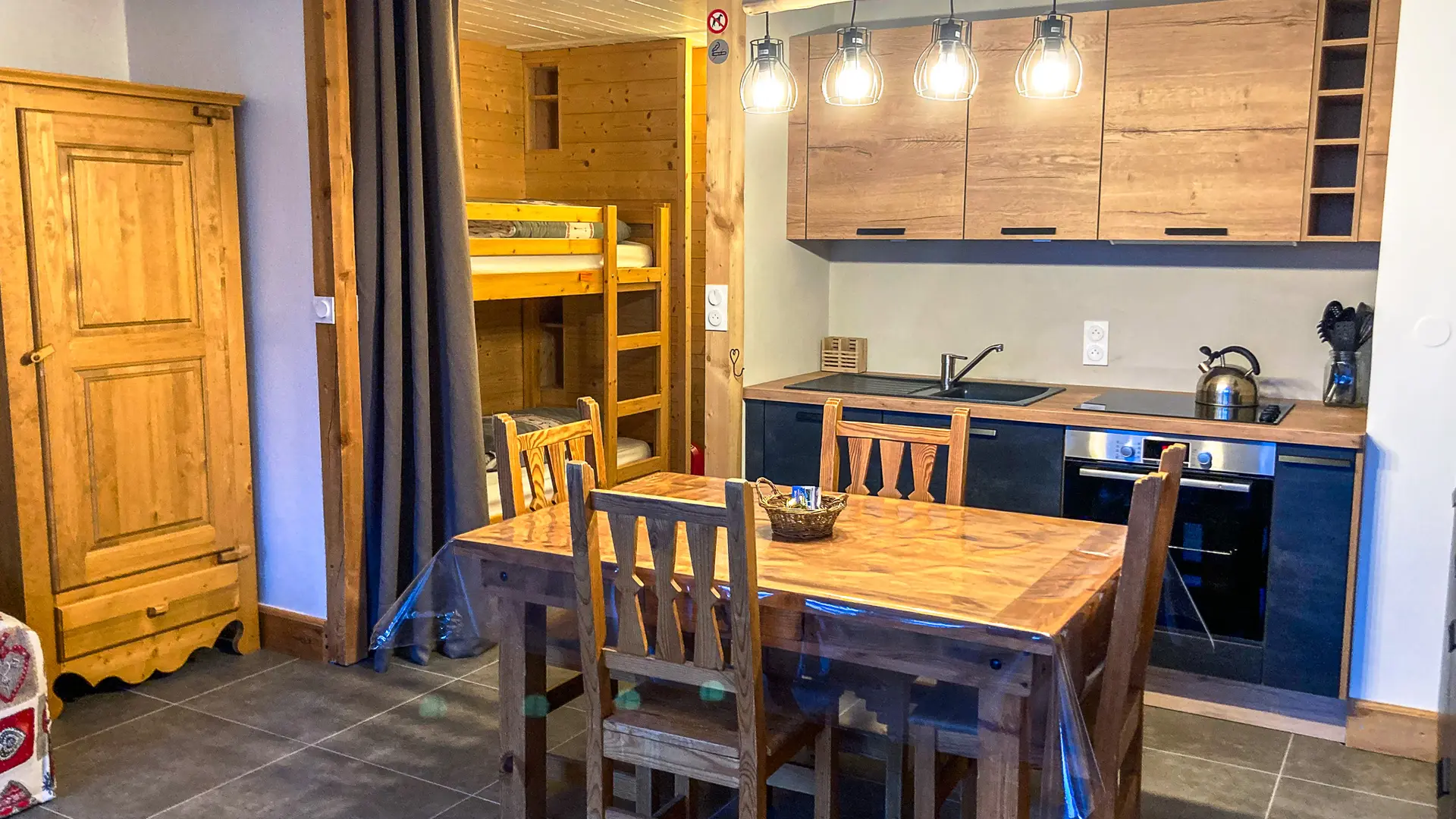 Salon avec 2 lits simples superposés séparés par un rideau