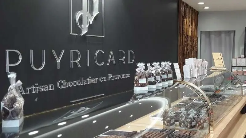 Chocolaterie Puyricard_L'Isle-sur-la-Sorgue logo mural + vitrine de chocolats