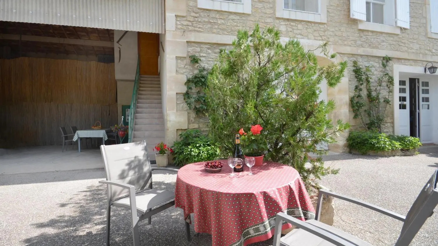 terrasse couverte et cour, entrée au gîte par l'escalier