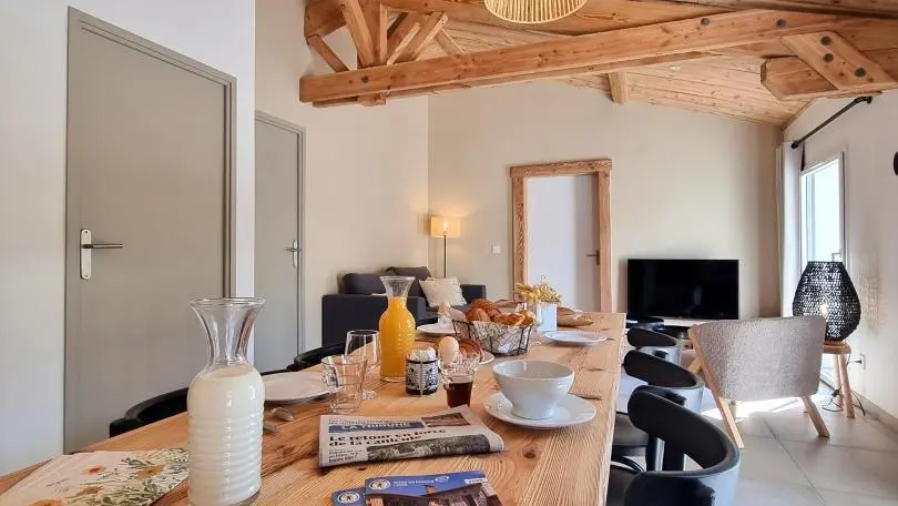 Séjour avec cuisine ouverte sur la salle à manger et le salon.