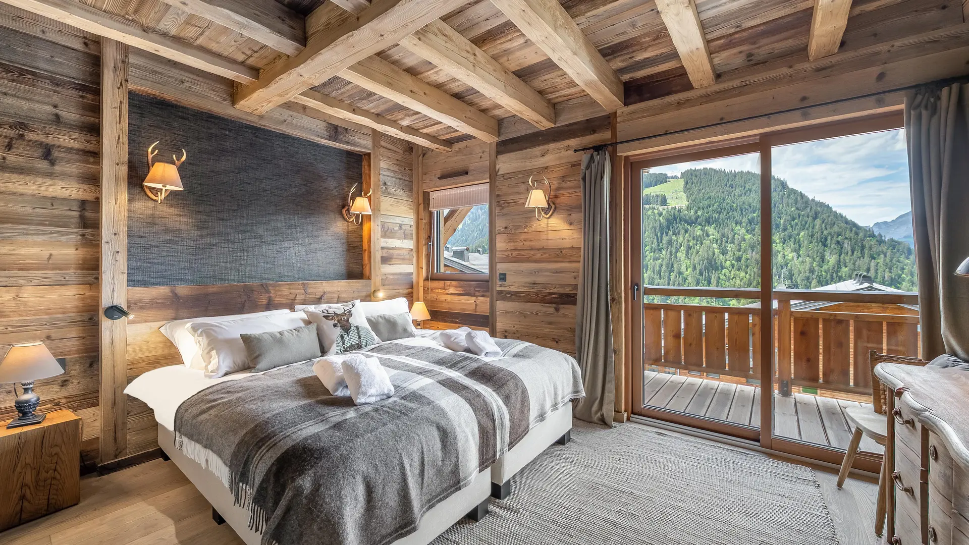 Chambre avec lits juemelés, décoration et ameublement très modernes, poutres apparentes, très lumineuse, accès balcon
