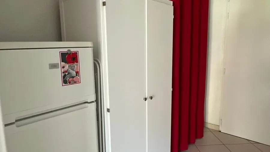 Une entrée avec une grande armoire et réfrigérateur/congélateur.