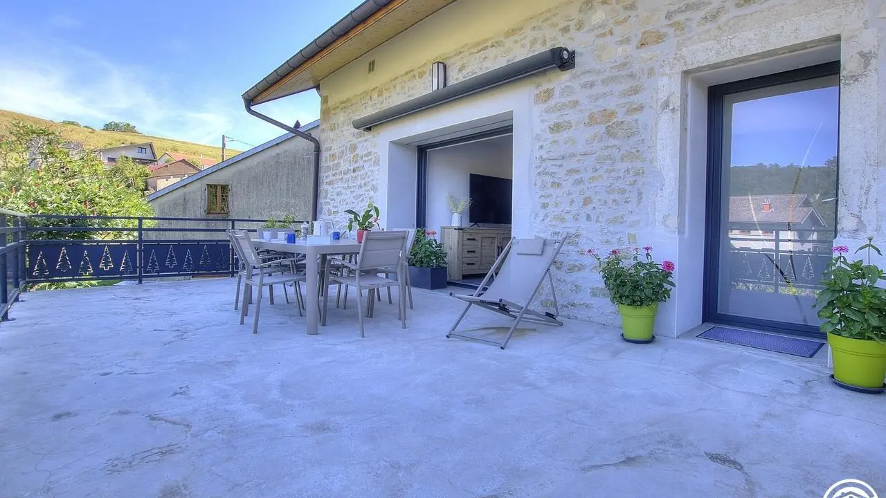 Grande terrasse privée au gîte avec vue sur le potager des propriétaires et le village.