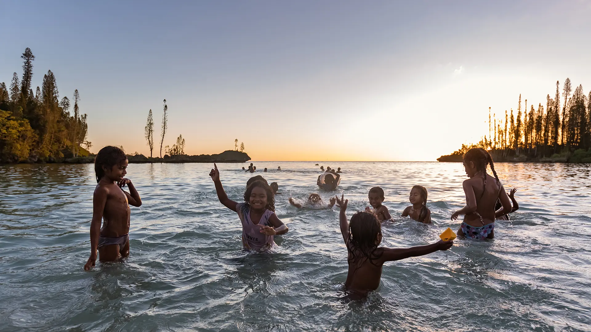 Children in the sea at sunset