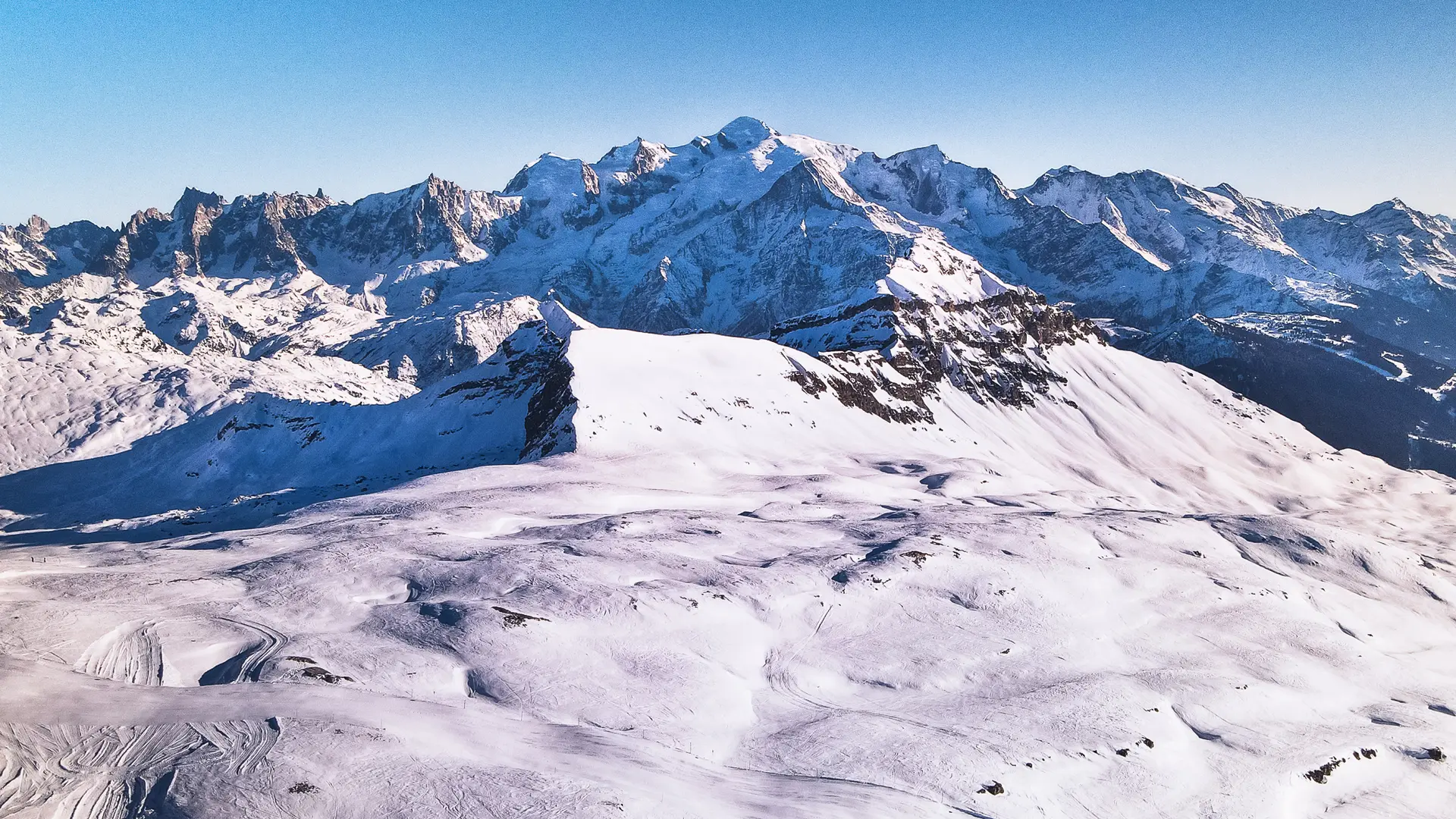 Aerial view offering a panoramic view of the Mont Blanc massif, with the snow-covered Platé refuge below on the right
