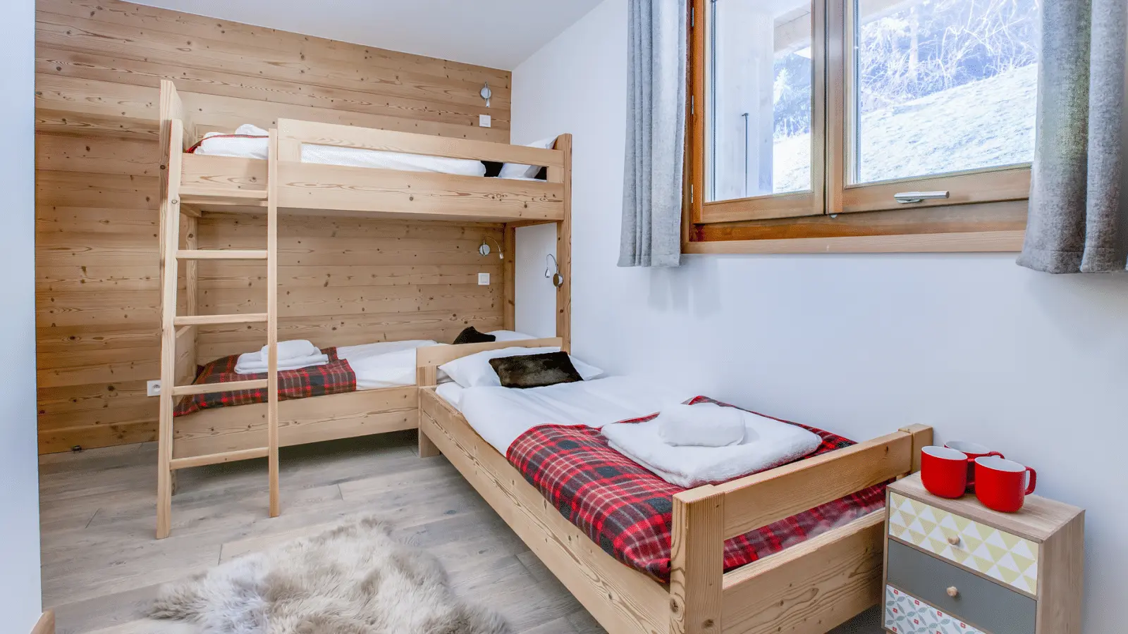 Chambre pour enfants avec un lit superposé et un lit simple ambiance chalet chaleureux et convivial