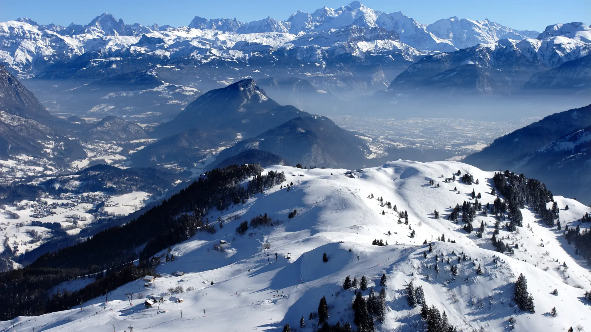 Vue sur le domaine skiable du Massif des Brasses et la chaine du Mont Blanc au loin