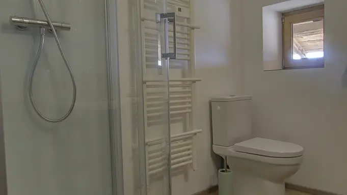 La salle d'eau avec cabine de douche, lavabo et toilette.