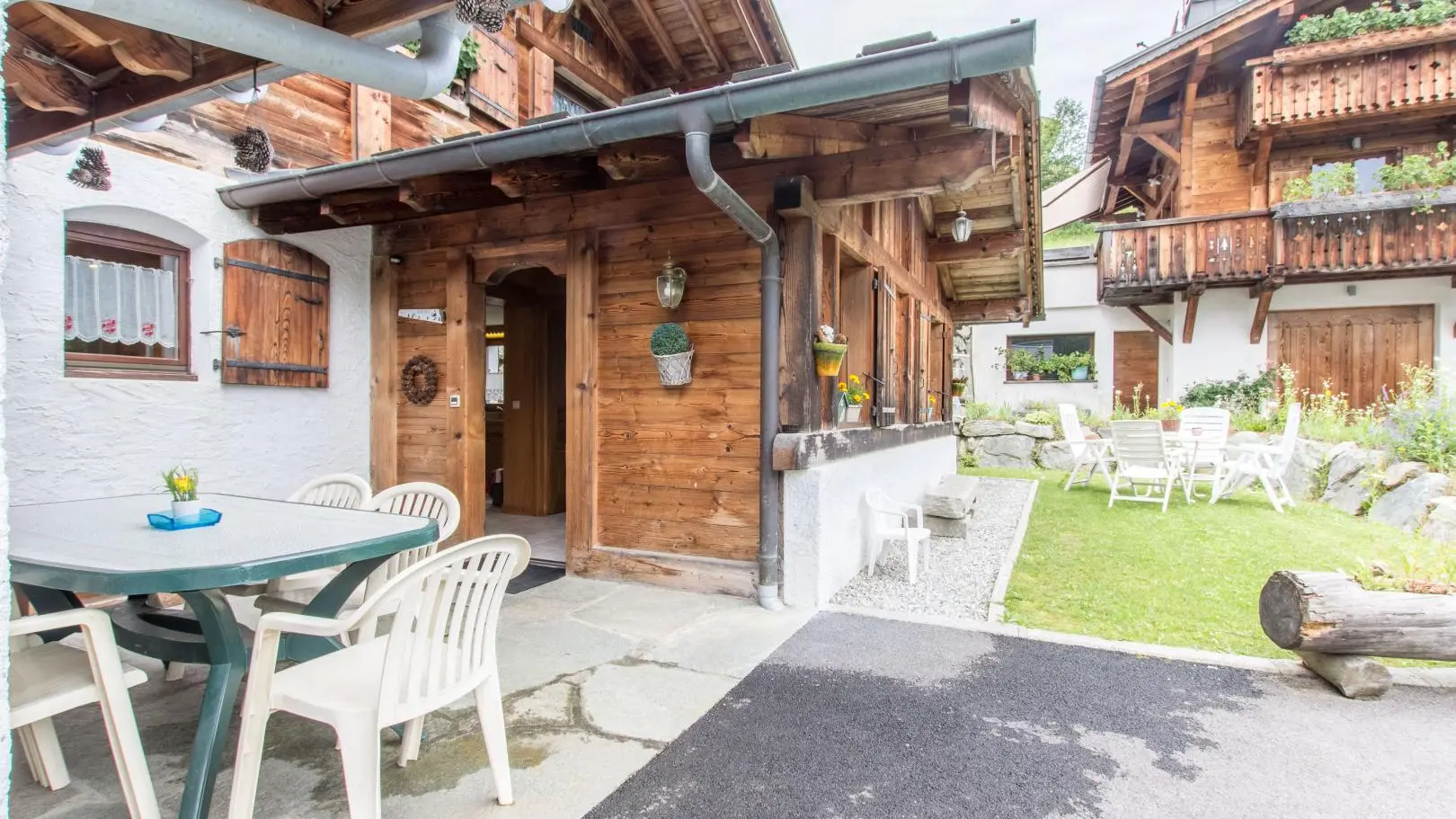 Entrée du gîte avec jardin tout le tour du bas de chalet table chaise chaise longue pour vous dètentre