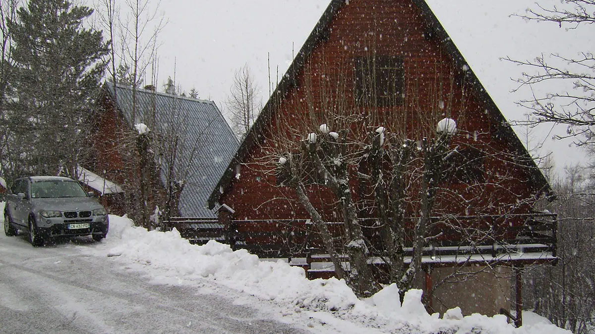 wooden chalet with balcony, window, snowy landscape