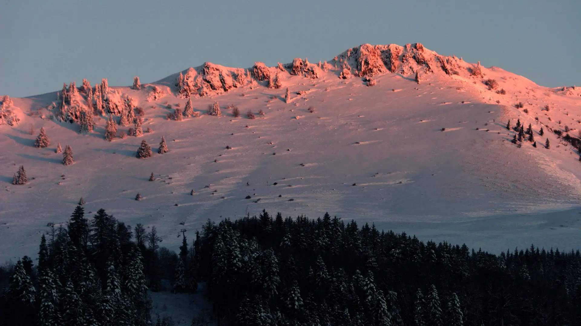 Coucher de soleil sur les crêtes enneigées.