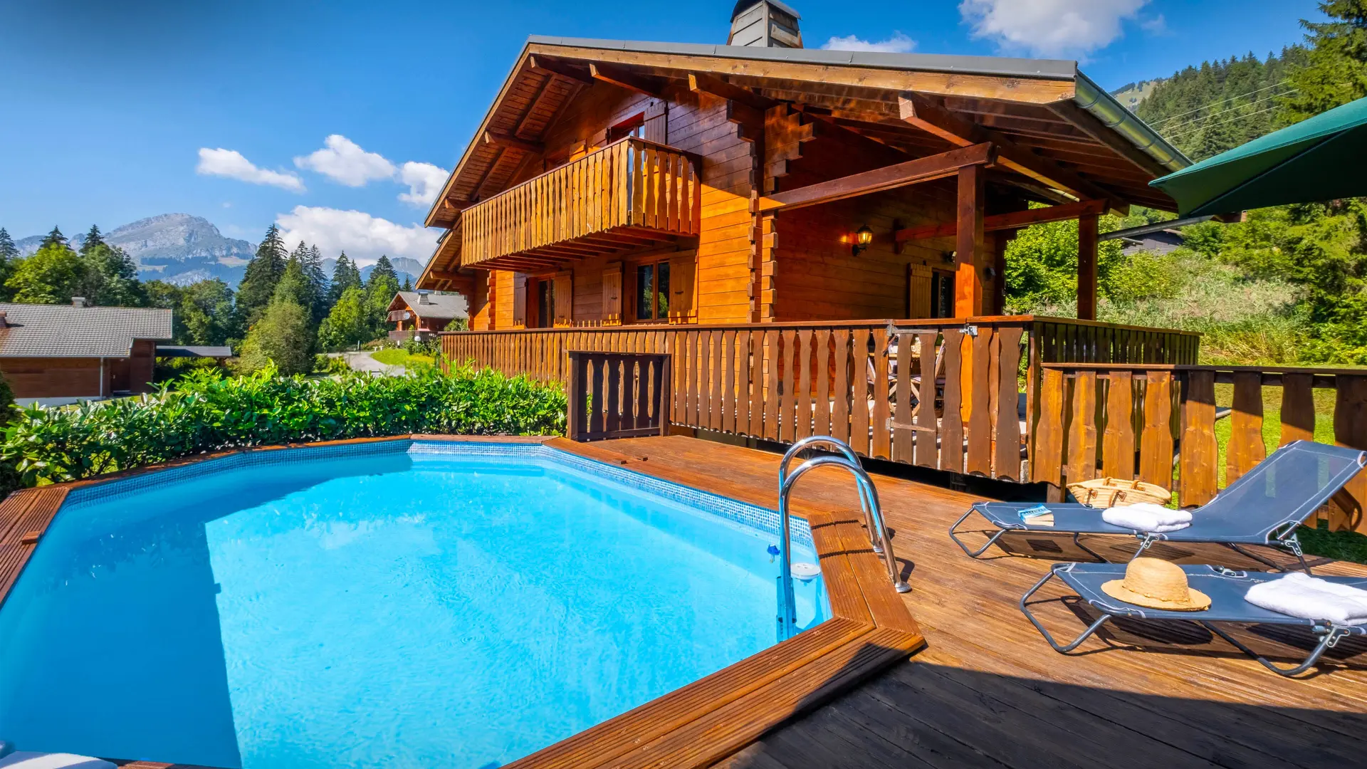Extérieur du chalet en été avec sa piscine et terrasse