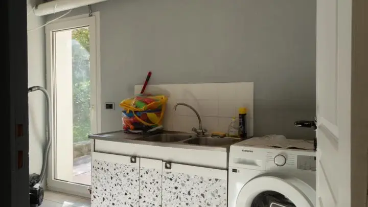 Buanderie avec réfrigérateur d'appoint et accès terrasse