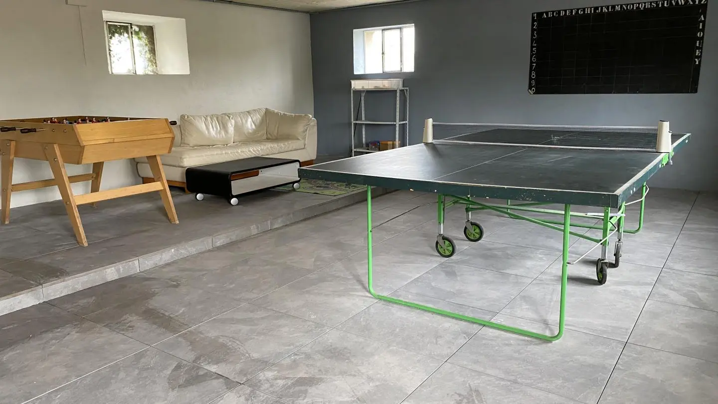 Table de ping pong et babyfoot dans la salle de jeux.
