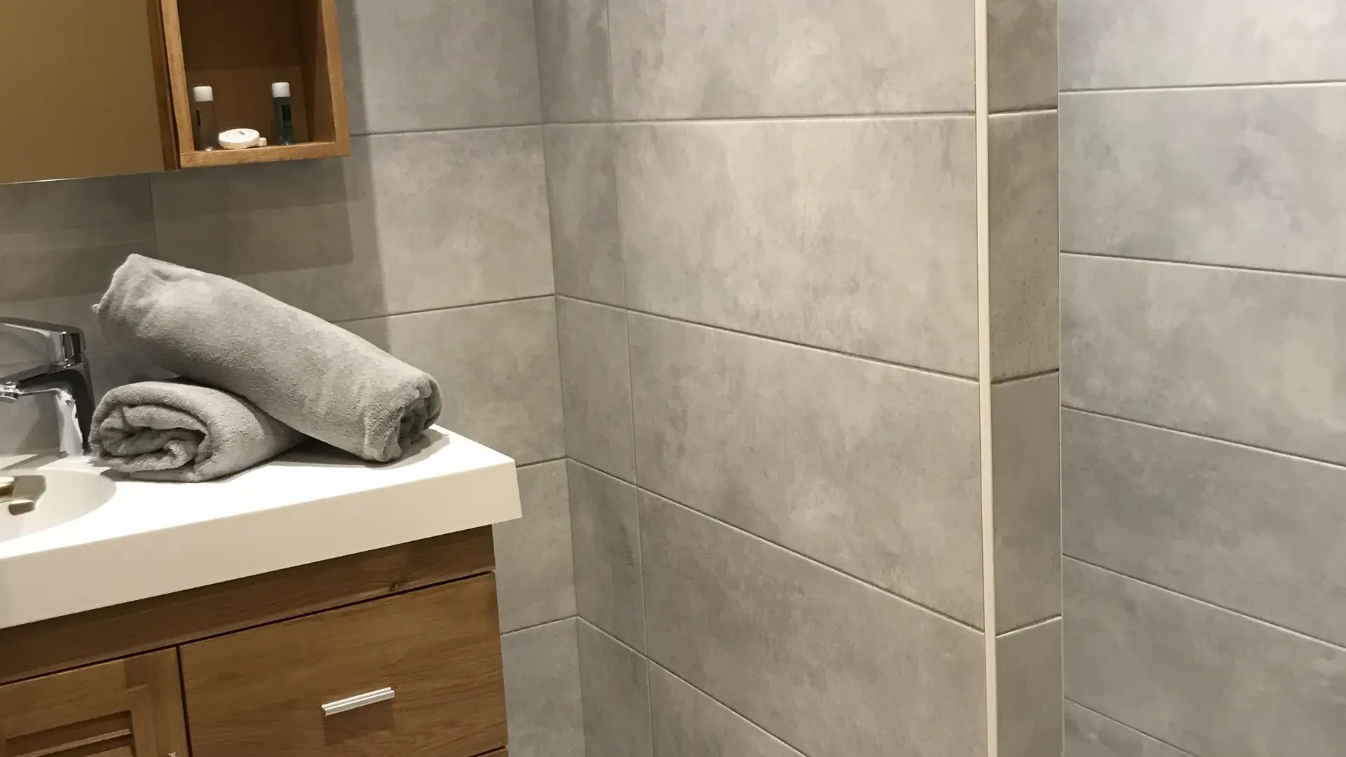 Salle de bains avec douche à l'italienne, meuble et vasque