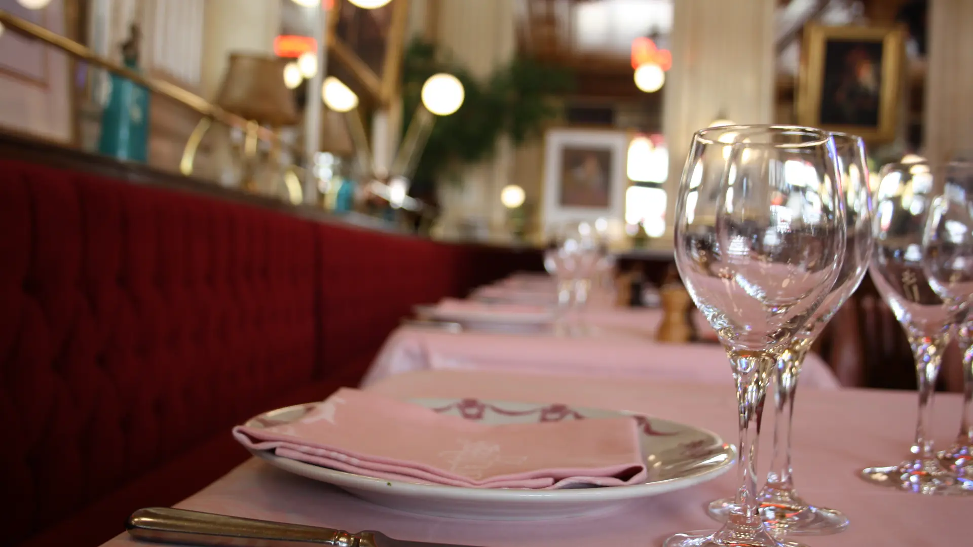 Table dressée avec en premier plan des verres, assiette et couverts