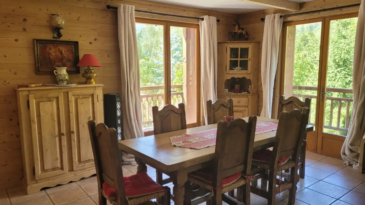 Salon d'appartement lumineux avec table à manger, ameublement bois, portes-fenêtres, carrelage au sol