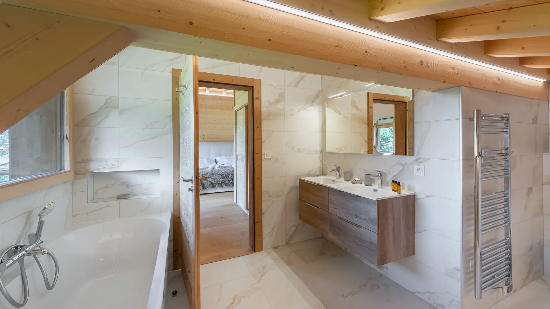 Salle de bains avec bagnoire, double vasque avec  son meuble et grand miroir, sèche serviettes
