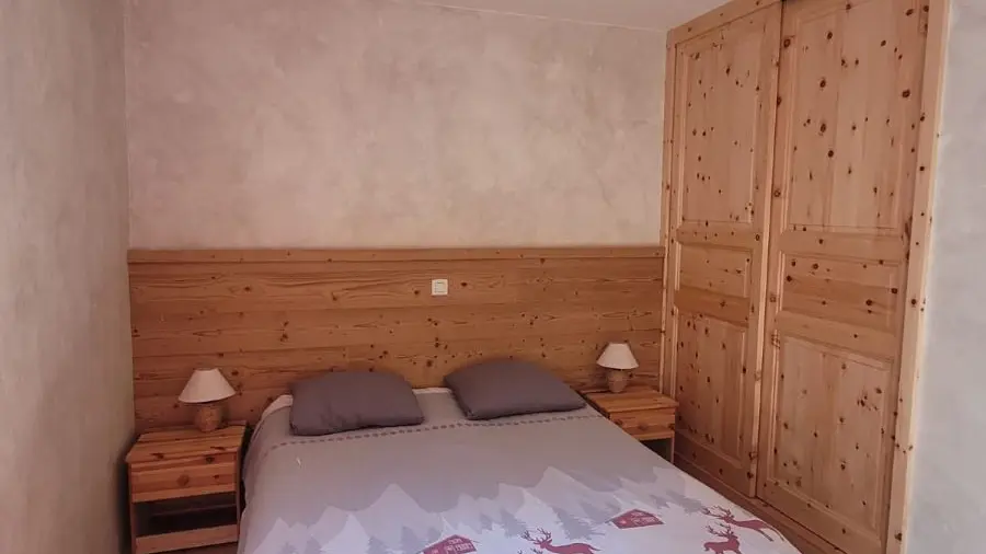 Chambre à coucher avec lit double, ameublement bois, sol carrelé