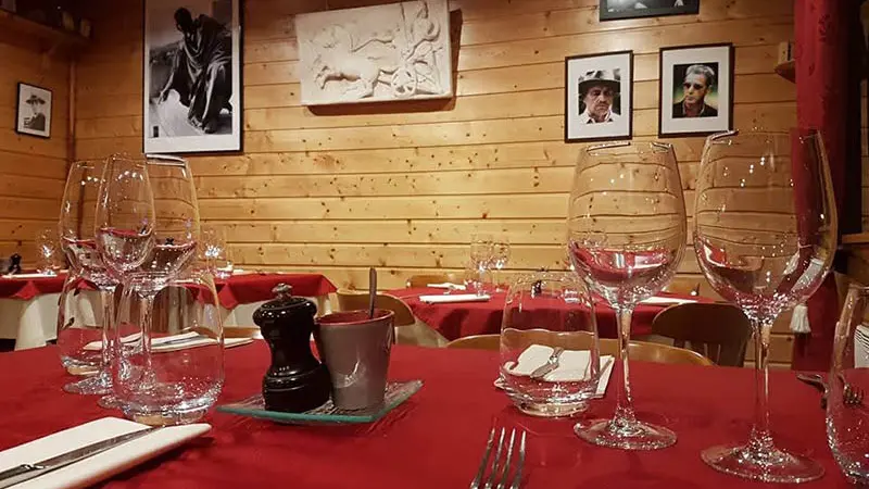 Intérieur du restaurant, décoration bois, tables et chaises ambiance chaleureuse, portraits et photos anciens sur les murs