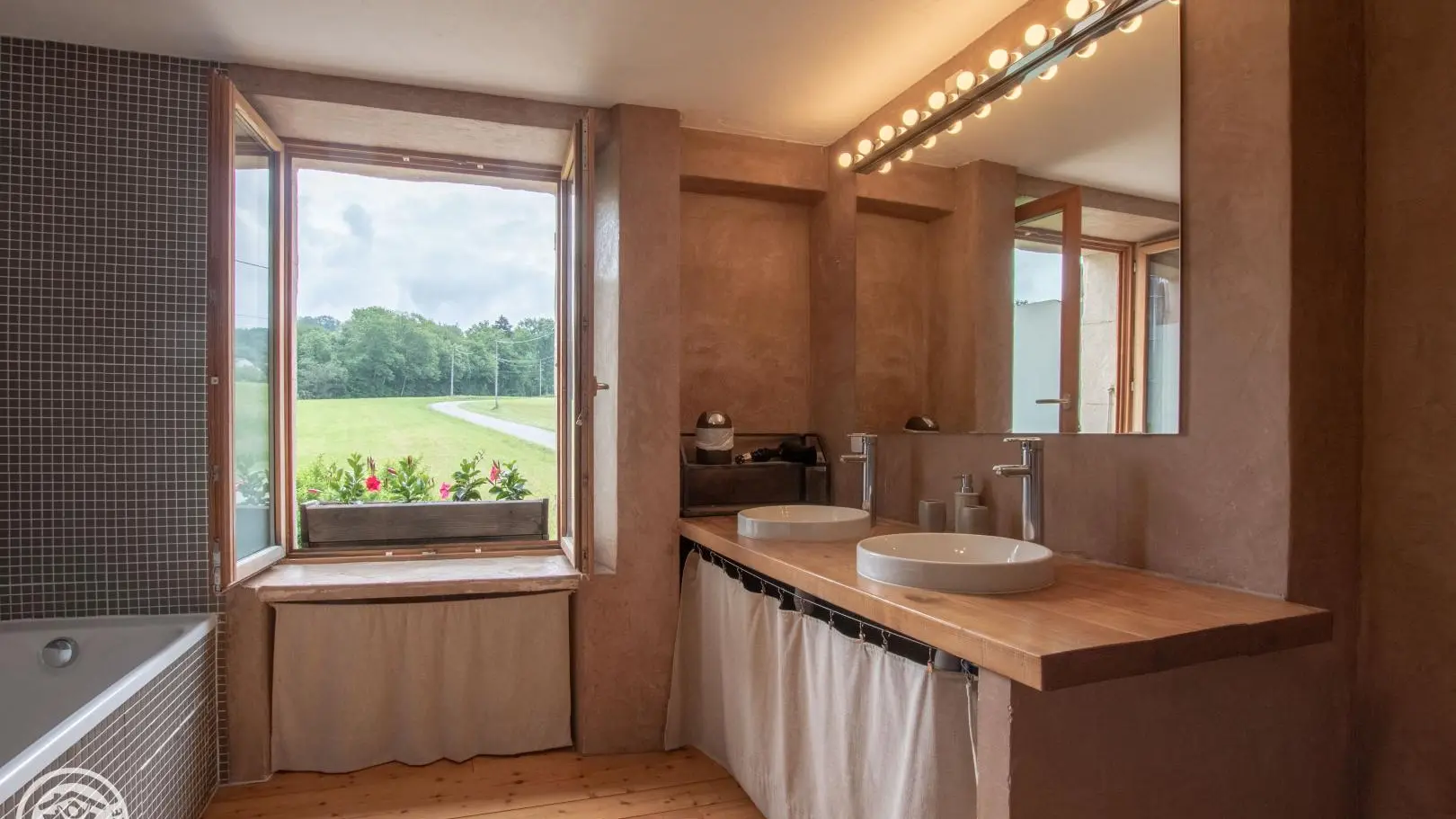 La grande salle de bain, commune aux deux chambres, avec double vasque, grande baignoire et douche.