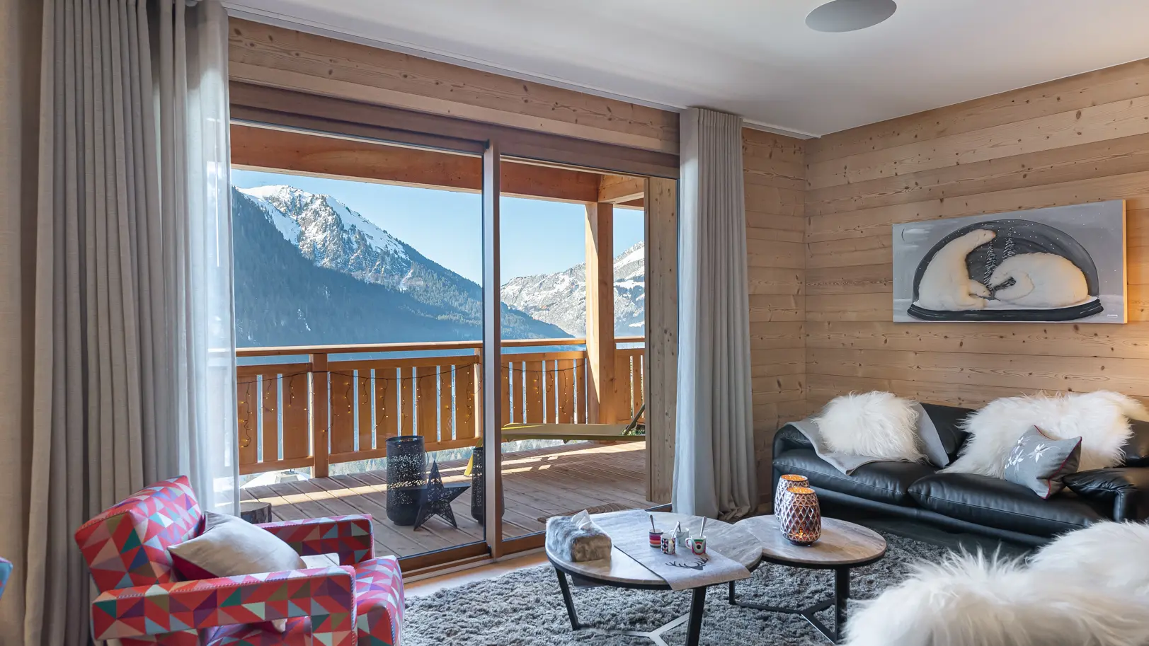 Coin salon avec fauteuils, canapés, grand balcon terrase, vue sur les montagnes