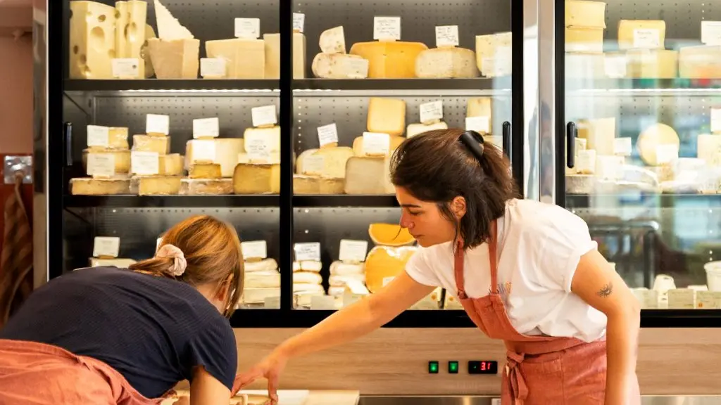 deux femmes en train de préparer un plateau de fromage