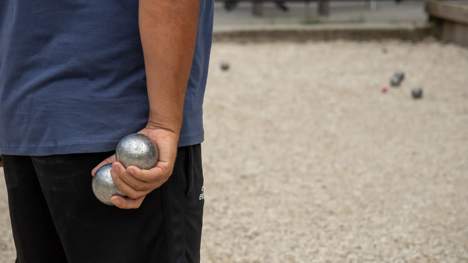 Speler met petanqueballen in de hand