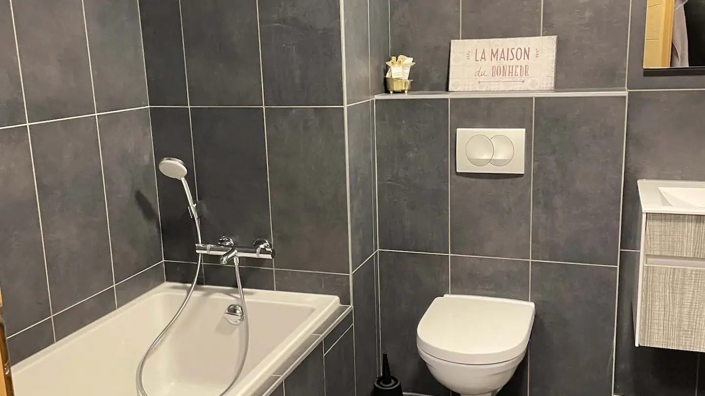 Salle de bains avec baignoire, toilettes et lavabo