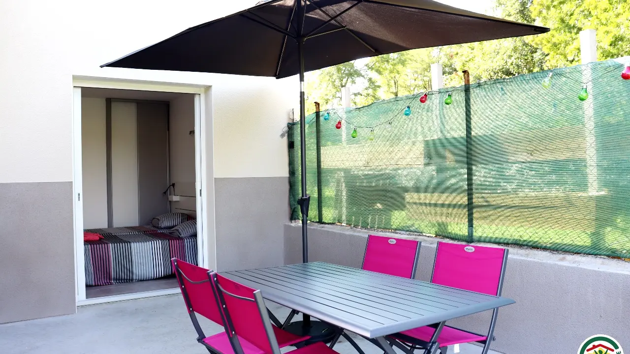 Terrasse avec table à manger et plancha gaz.