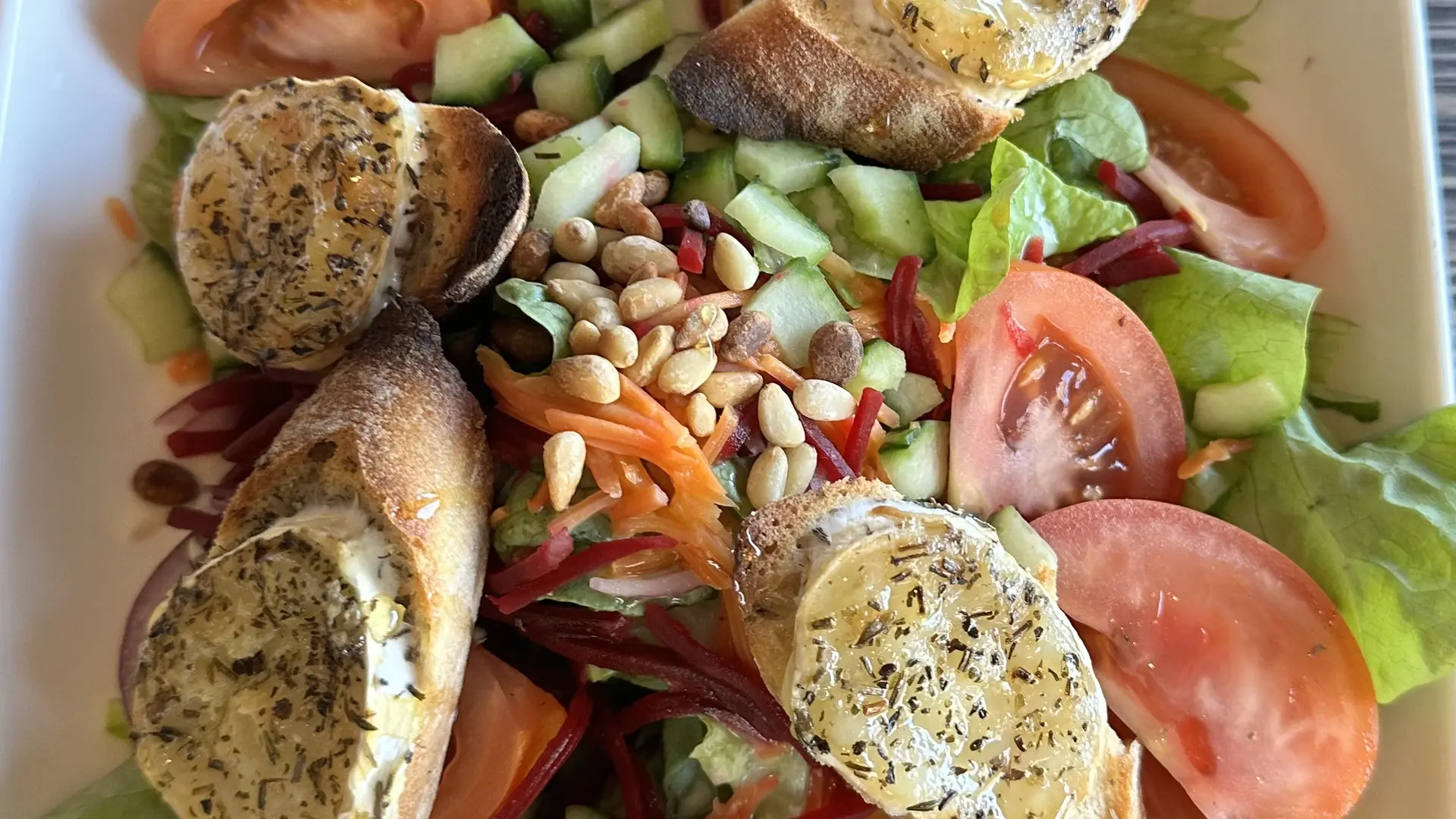 assiette salade verte tomate croûtons fromage de chèvre pignons de pin