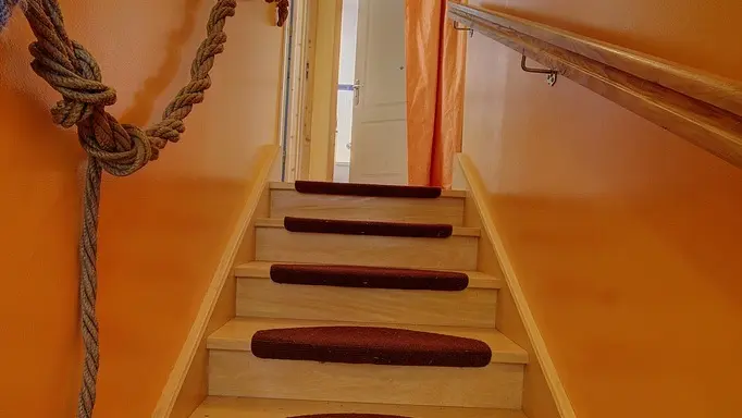 Depuis le hall d'entrée, un escalier mène à la chambre familiale et la salle de bain mitoyenne.