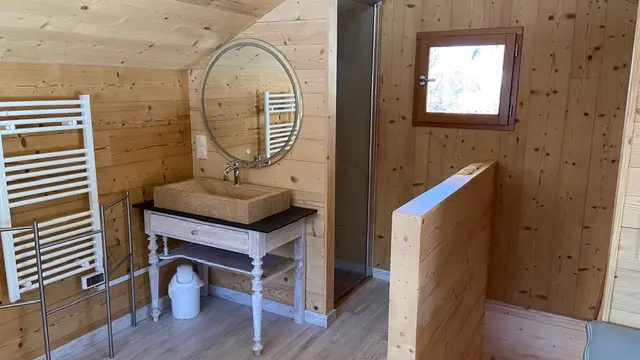 Espace salle de douche tout en bois, type chalet, avec un évier et une douche.