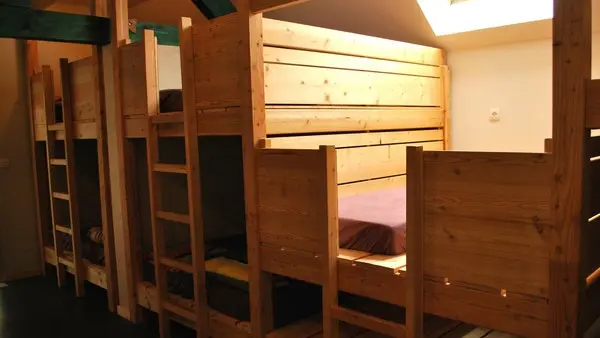 Lits superposés en bois dans la partie dortoir du Gîte des Hauts Plateaux