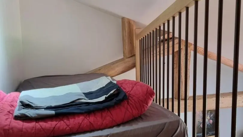 Couchage d?appoint lit 80x190xm en mezzanine mansardée, accessible par la chambre 2 et ouvert sur le salon détente, idéal pour un enfant.