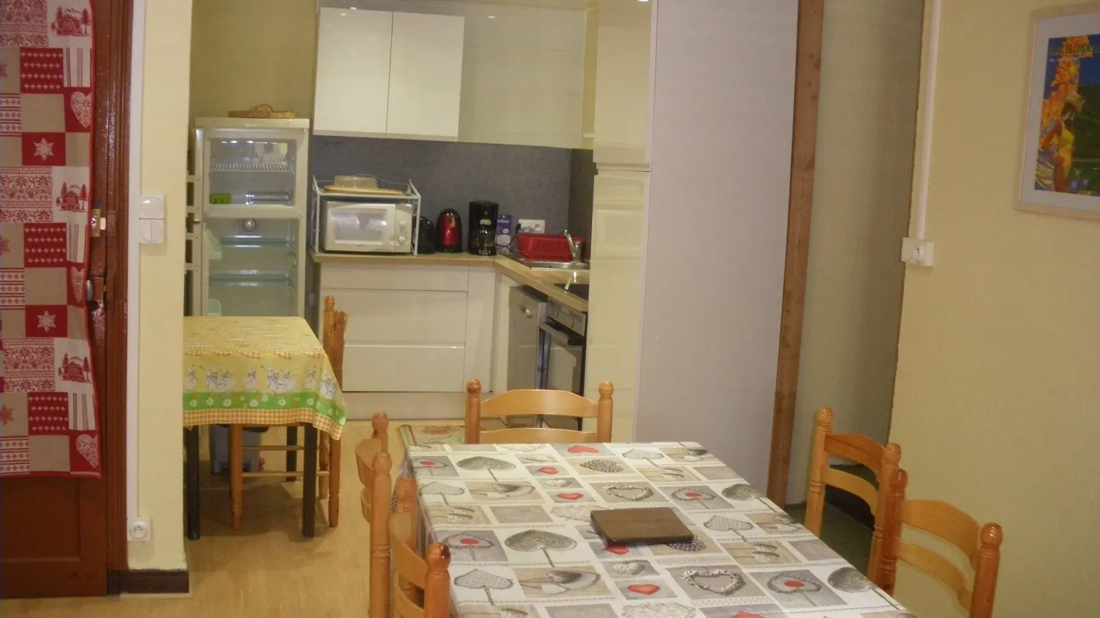 Séjour avec coin cuisine, table à manger, plaques électriques, four à micro-ondes, ameublement bois, parquet au sol