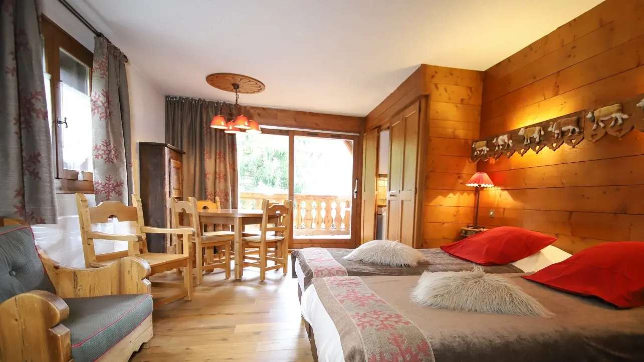 Uitzicht op een flat met eettafel en twee eenpersoonsbedden