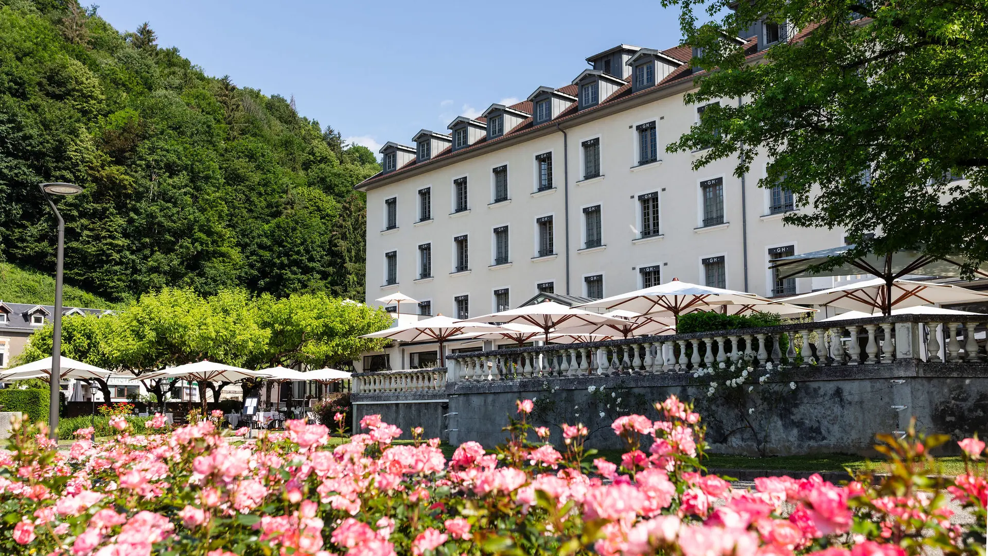 La façade du Grand Hôtel d'Uriage et la terrasse de son restaurant, la table d’Uriage, prise depuis le parc thermal.