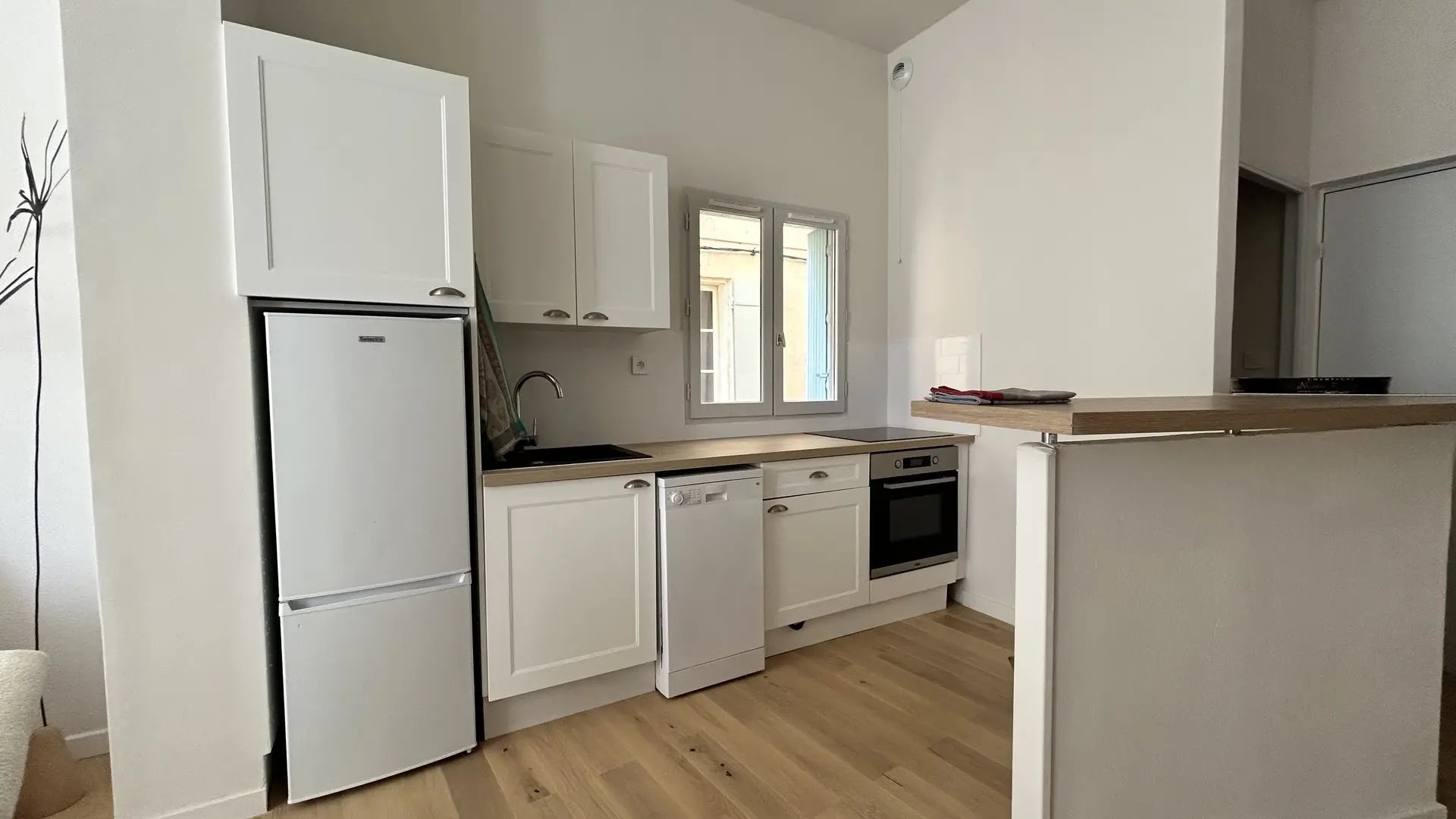 Une cuisine moderne et fonctionnelle, entièrement équipée, ouverte sur la pièce de vie pour plus de convivialité.