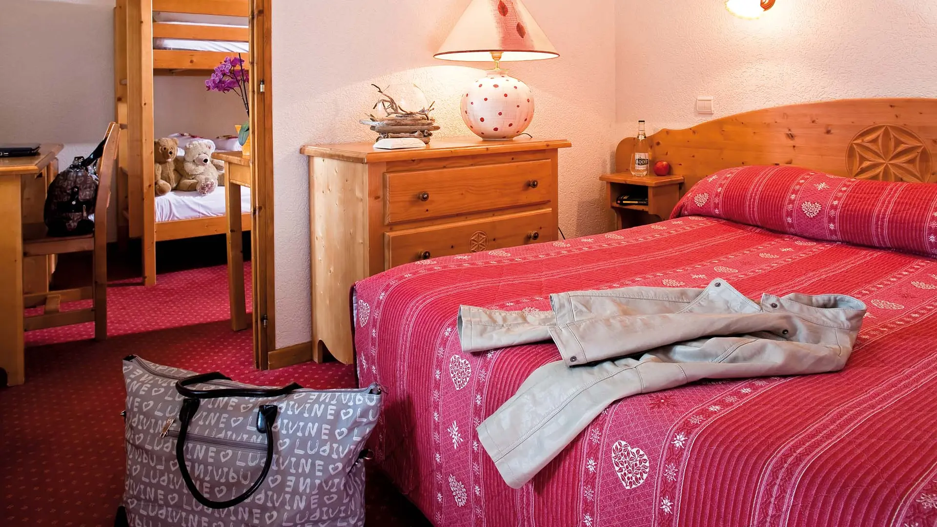 Chambre avec lit double et coin enfants séparé avec lits superposés