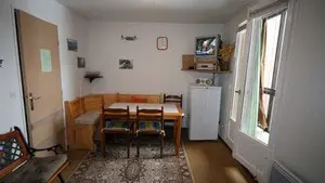 Séjour lumineux avec table à manger, tapis, canapé, banquette, TV, ameublement bois, fenêtre